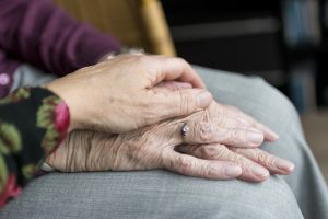 Woman holding elderly mother's hand